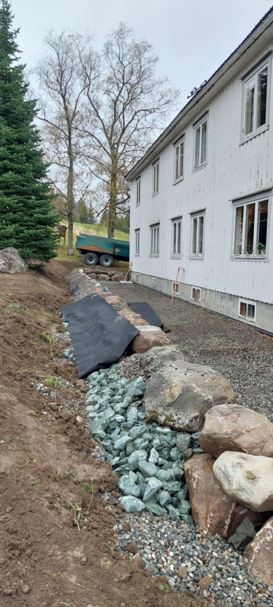 Graving av dreneringsgrøft langs bygning